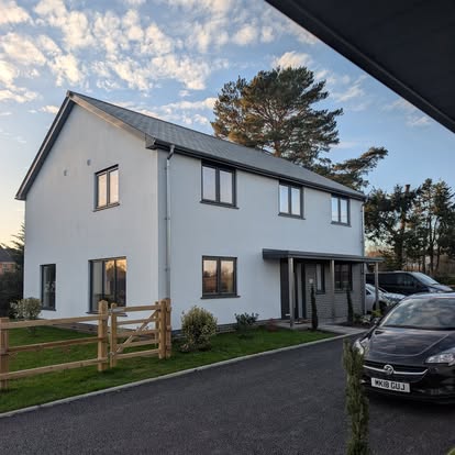 Modern white rendered exterior with charcoal window frames